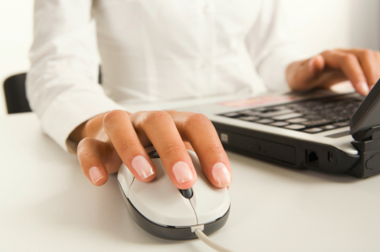 Womans hands touching computer mouse and keys of black opened laptop